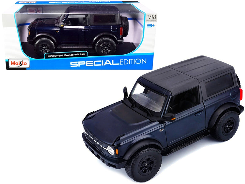 2021 Ford Bronco Wildtrak dark blue metallic diecast model car by Maisto, featuring dark gray top, detailed 1/18 scale vehicle.