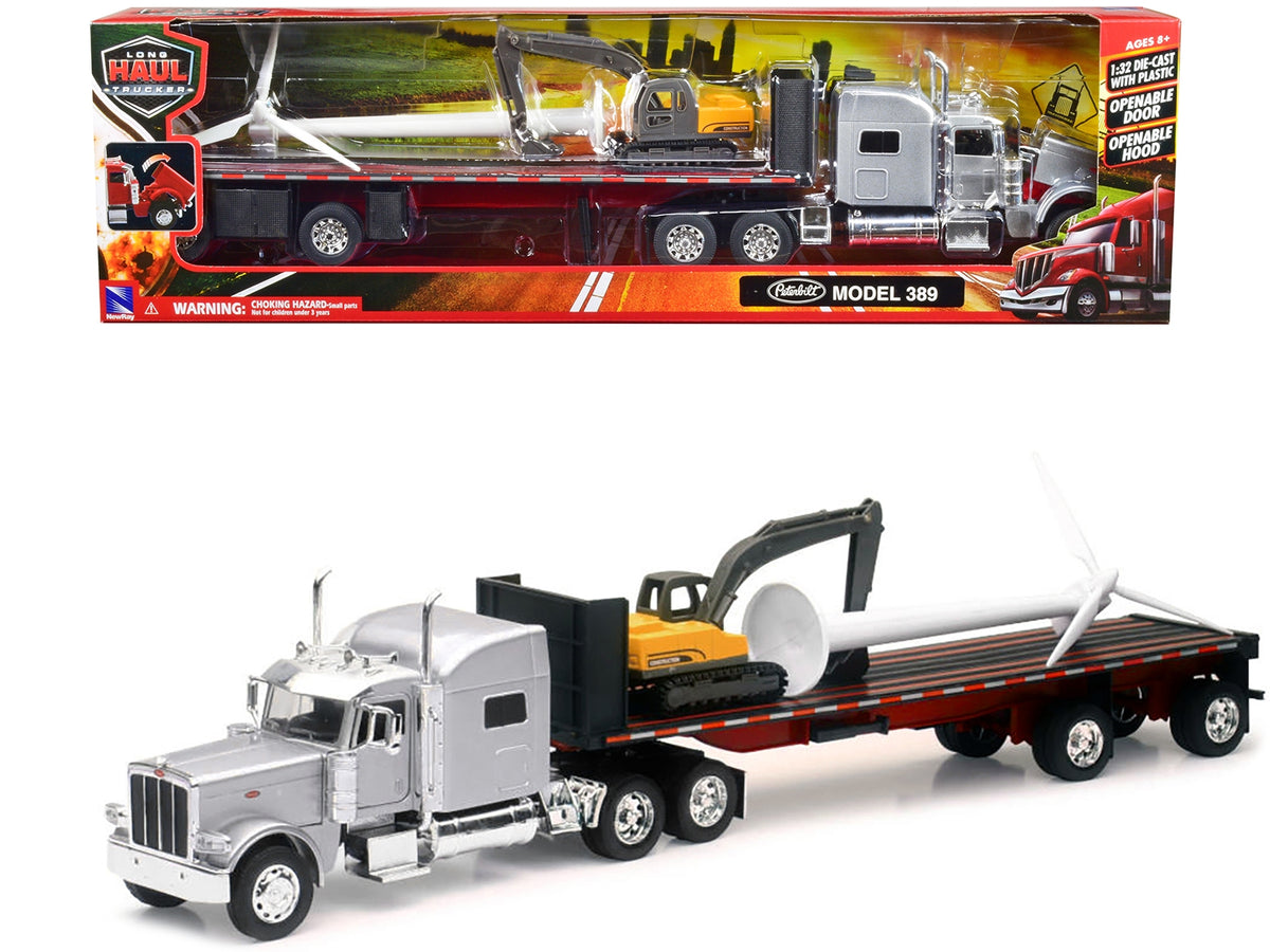 Silver metallic Peterbilt 389 truck with flatbed trailer, excavator, and wind turbine diecast model by New Ray.
