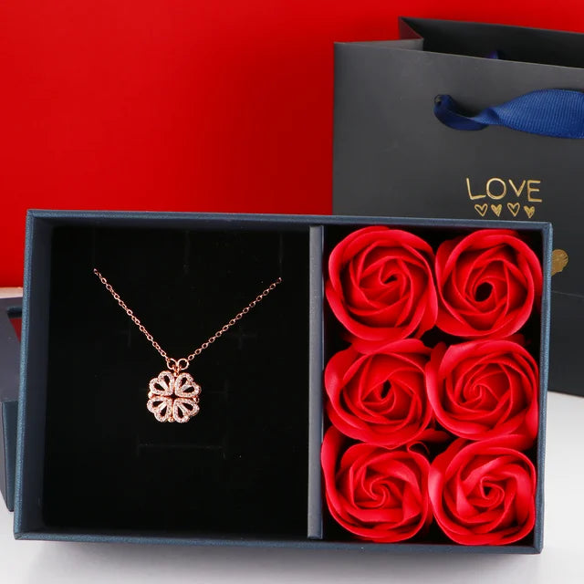 Dainty four-leaf clover and magnetic heart necklace by American Smart EP, displayed in a rose jewelry box, perfect for Mother's Day.