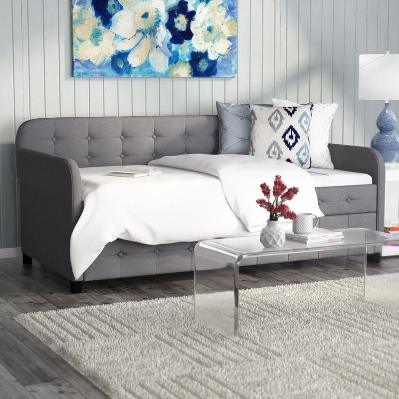 Gray tufted polyester linen twin daybed with trundle, featuring a classic design and plush cushioning for versatile bedroom seating.
