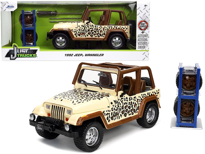 1992 Jada Jeep Wrangler diecast model car in tan and brown with graphics and extra wheels, part of the "Just Trucks" series.