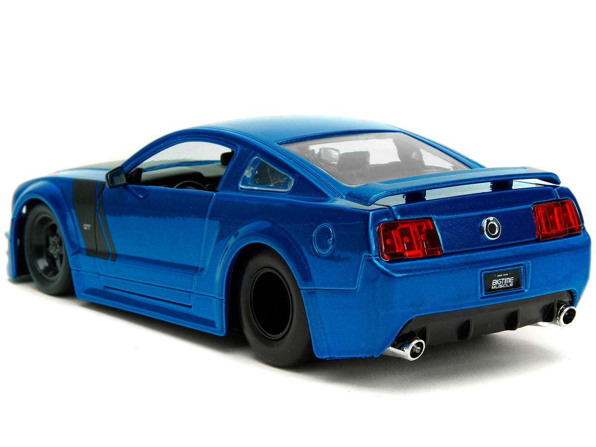 2006 Ford Mustang GT diecast model car by Jada, blue metallic with matte black hood and stripes, detailed 1/24 scale replica.