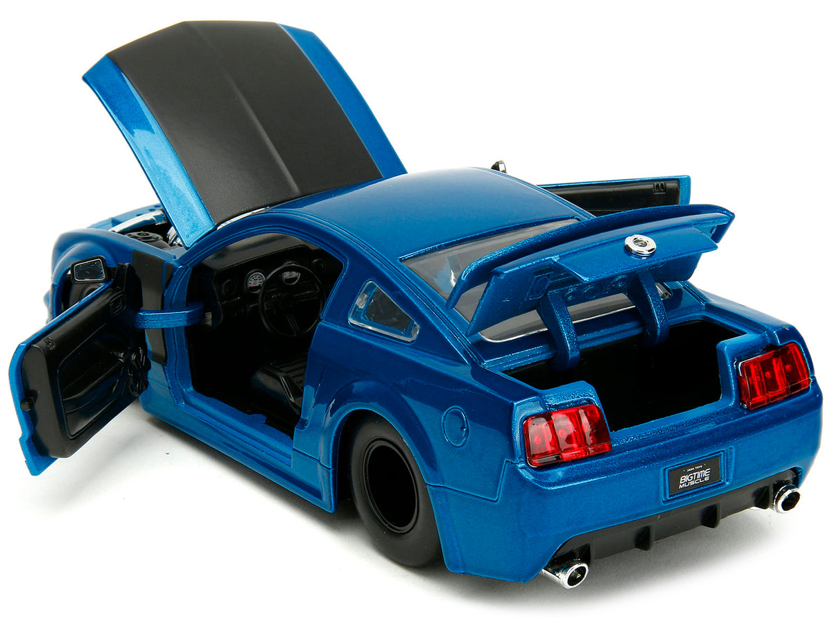 2006 Ford Mustang GT diecast model car by Jada, blue metallic with matte black hood and stripes, part of Bigtime Muscle series.
