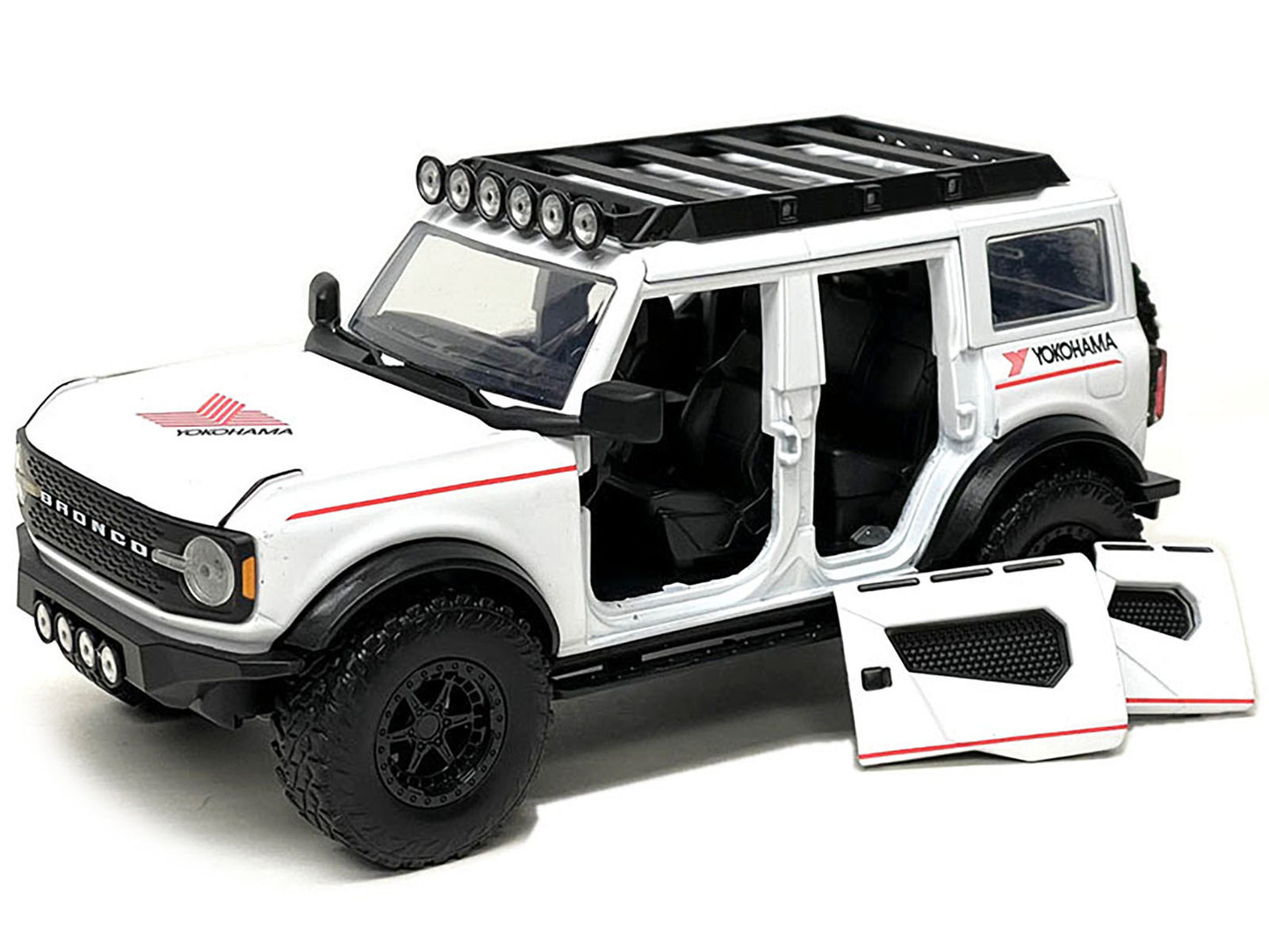 2021 Ford Bronco diecast model in white with red stripes and roof rack, by Jada, part of the Yokohama Tires series, 1/24 scale.