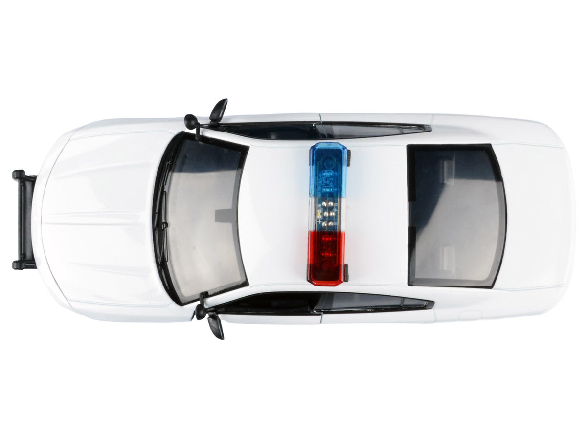 2023 Dodge Charger Pursuit police car diecast model by Motormax, unmarked white with flashing light bar, front and rear lights, and sound features.