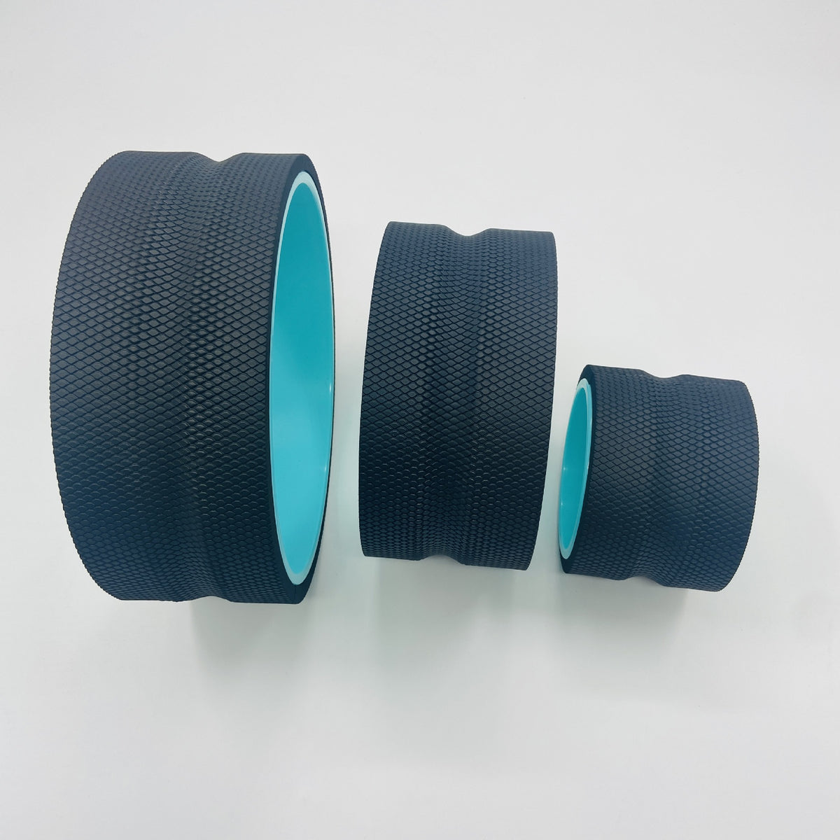 Set of three EVA yoga wheels, including massage stick and Pilates abdominal wheel, for back bends and stretching exercises.
