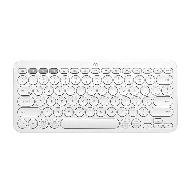 Logitech K380 Mini Bluetooth wireless keyboard with tablet and phone setup, showing compact design and keys in a natural office setting.