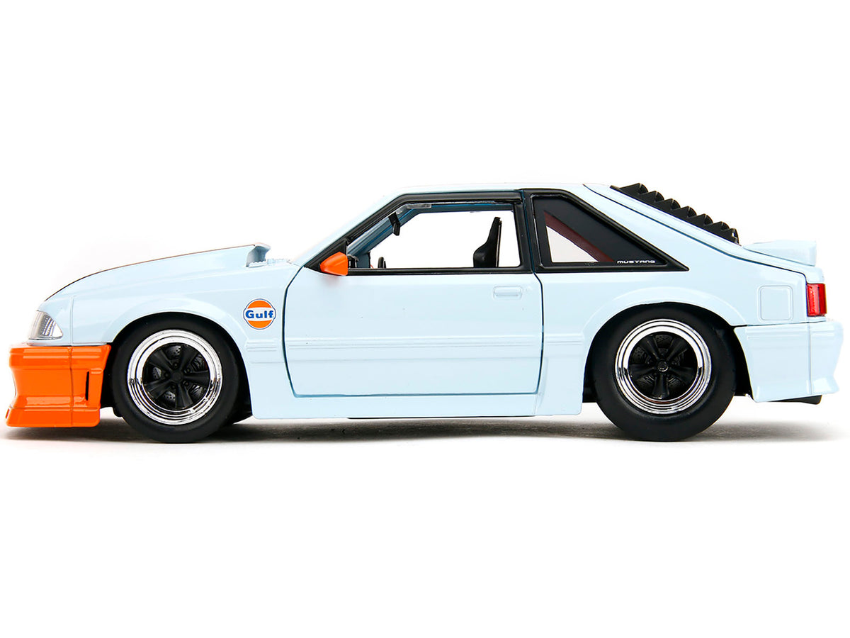 Light blue 1989 Ford Mustang GT "Gulf Oil" diecast model car with orange stripe, part of Bigtime Muscle series by Jada.