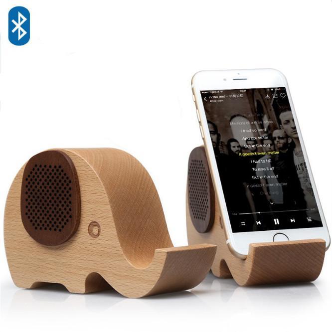 American Smart WOODSY GOODSY 2-in-1 Bluetooth speaker and cell phone stand, featuring wood grain finish and compact design.