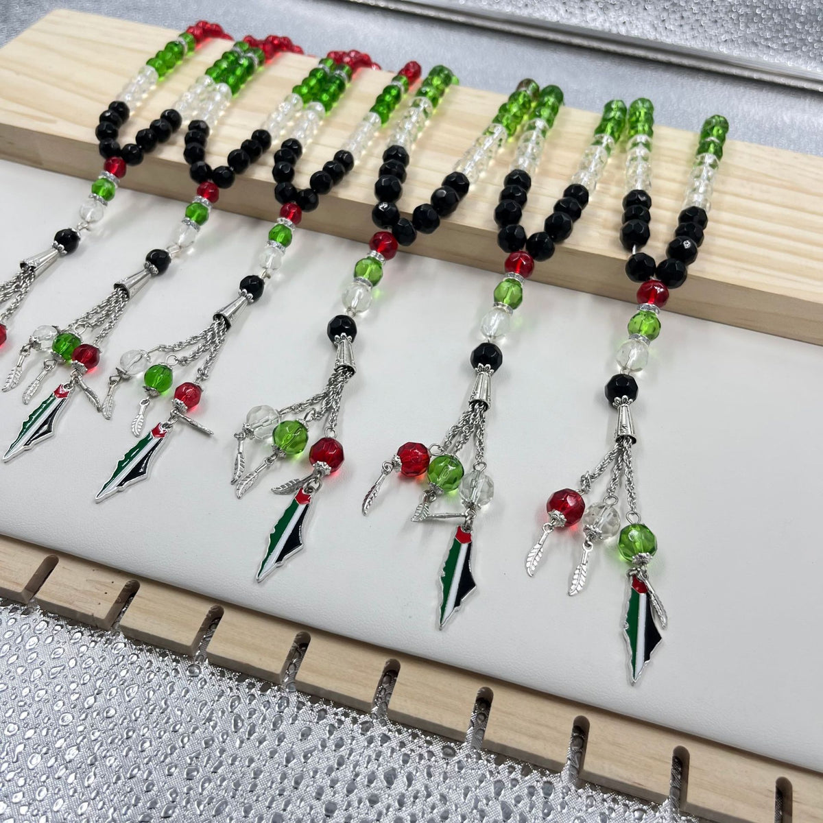 Eprolo 33 prayer beads in Palestinian flag-colored crystal glass with vibrant red, green, black, and white beads for spiritual reflection.