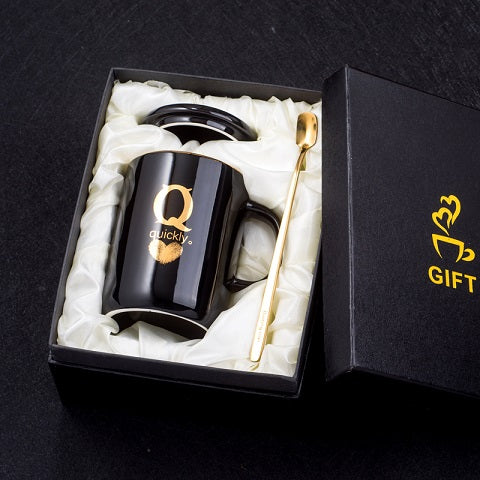 Black ceramic coffee mug with gold handle and lid, 400ml capacity, featuring gold fingerprint design and included spoon.