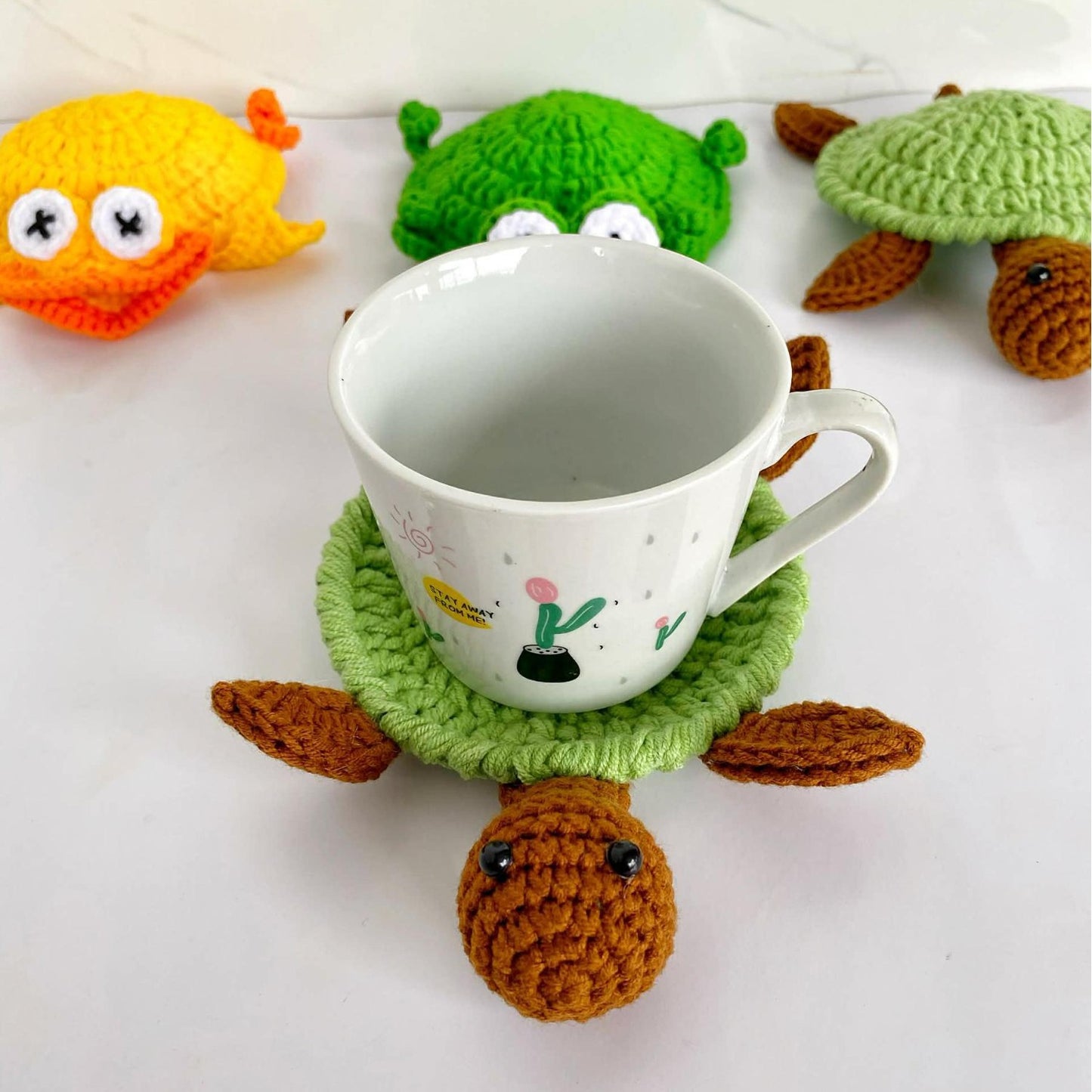 Handmade crochet animal coasters featuring a turtle and squirrel design, heat-insulating pads for desk or home decor.
