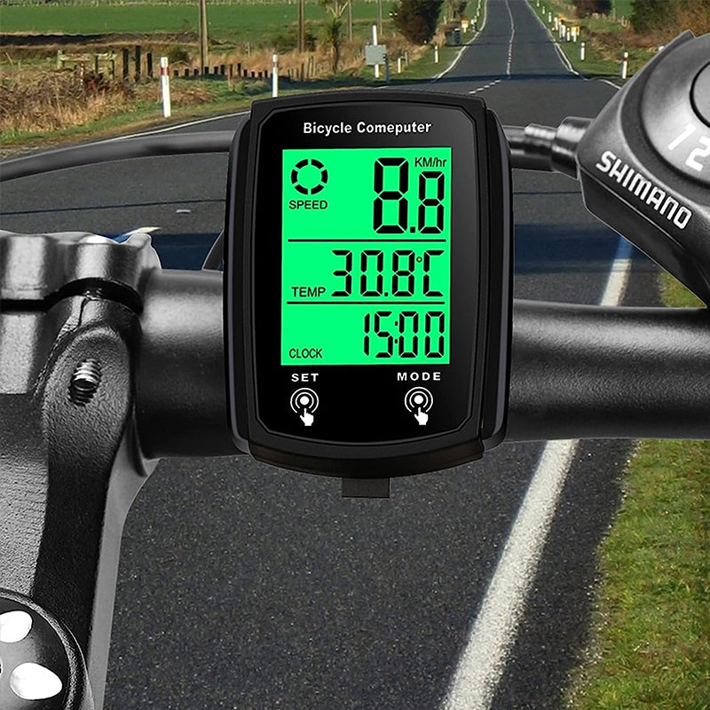 Wired LCD bicycle computer with backlight showing speedometer and odometer readings on a bike handlebar.