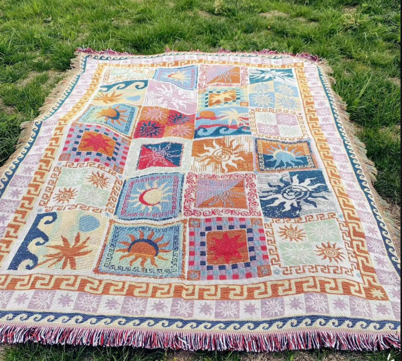 Eprolo multi-functional cotton blanket for camping, bedroom, and sofa, shown draped over a sofa cushion.