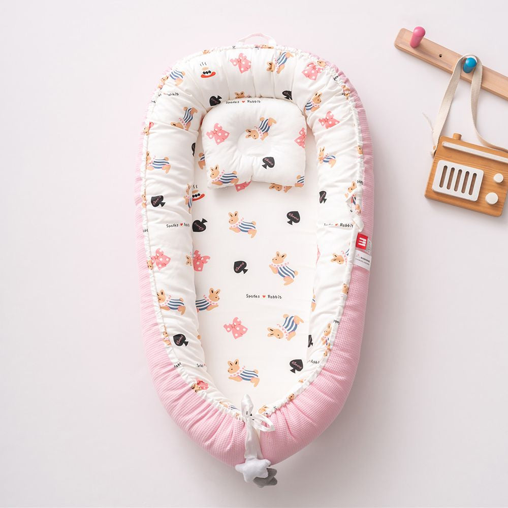 Eprolo portable baby crib with removable, washable baby pillow for travel and comfort, shown in a cozy setup.