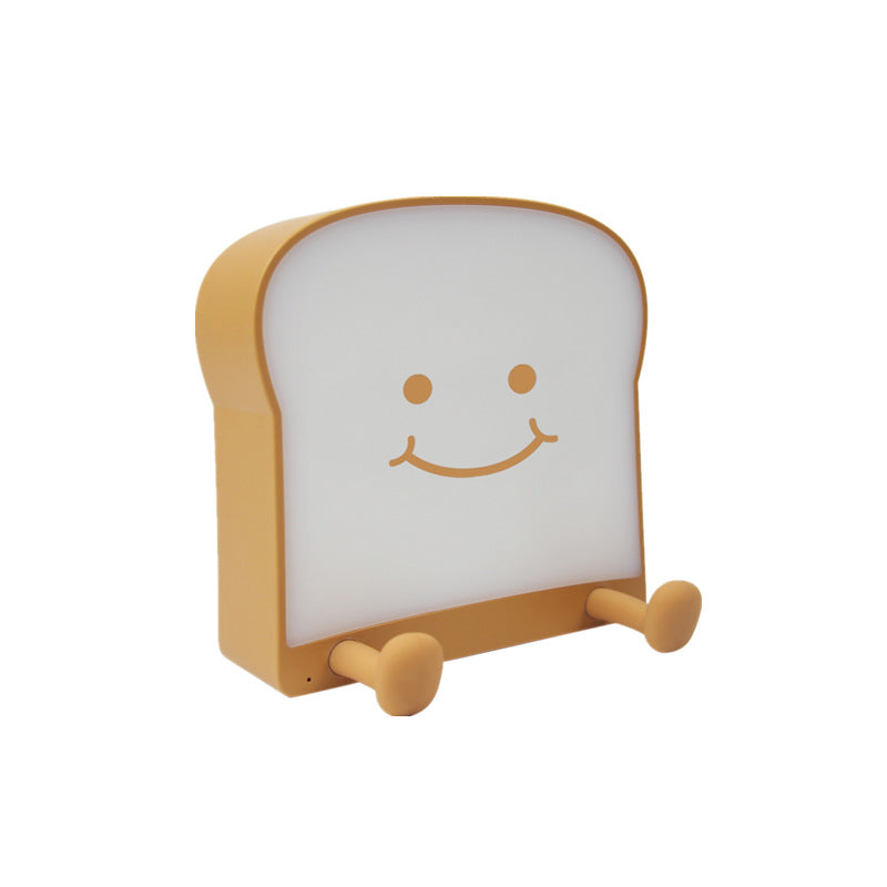 Eprolo toast bread night light with USB charging, square bread shape bedside lamp emitting warm light in a cozy bedroom setting.